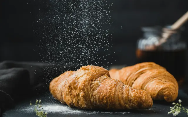 Croissant terminé avec de la farine en mouvement