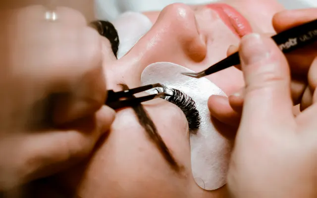 Professionnelle posant des extensions de cils