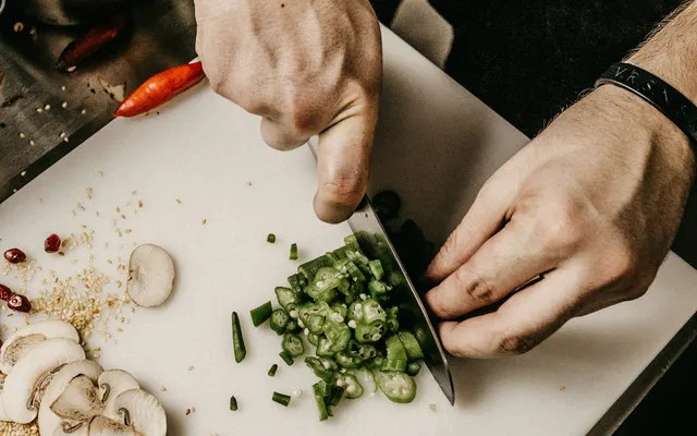 Cuisinier découpant des légumes frais